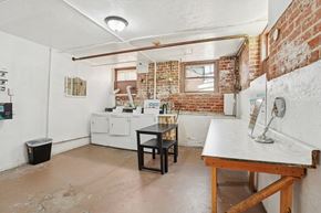 Torrance apartment for rent - A kitchen with a white fridge, a black table and a brick wall.